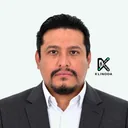 Retrato de Richard Carvajal, con chaqueta gris oscuro y camisa blanca, sobre fondo claro con el logo de Klinoda